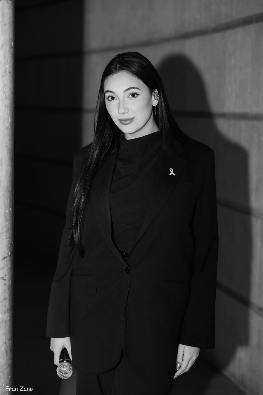 Black and white editorial portrait of a singer holding a microphone.
