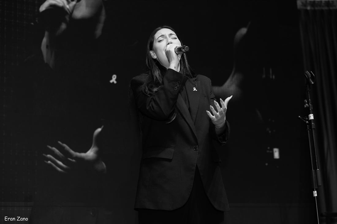 Black and white event photograph of a singer performing on stage.